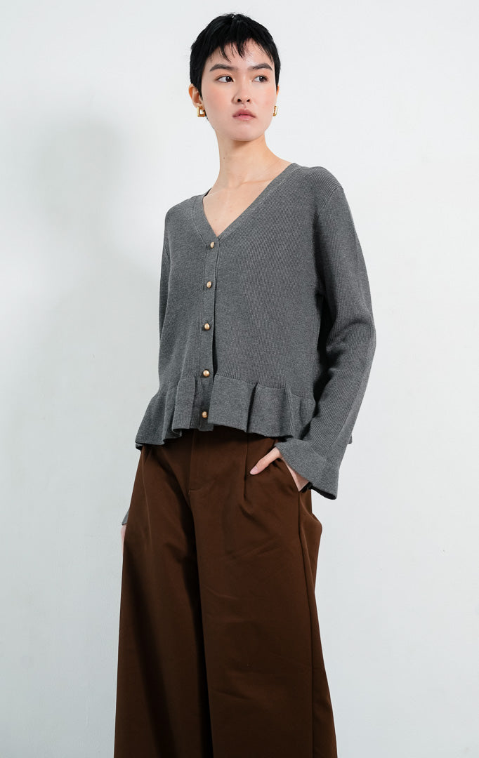 Kardigan rajut wanita lengan panjang warna abu-abu tua (dark grey) Eugenia Cardigan berstruktur knit dengan potongan pinggang mekar (peplum silhouette), leher V (V-neckline), dan kancing emas (gold-tone buttons).