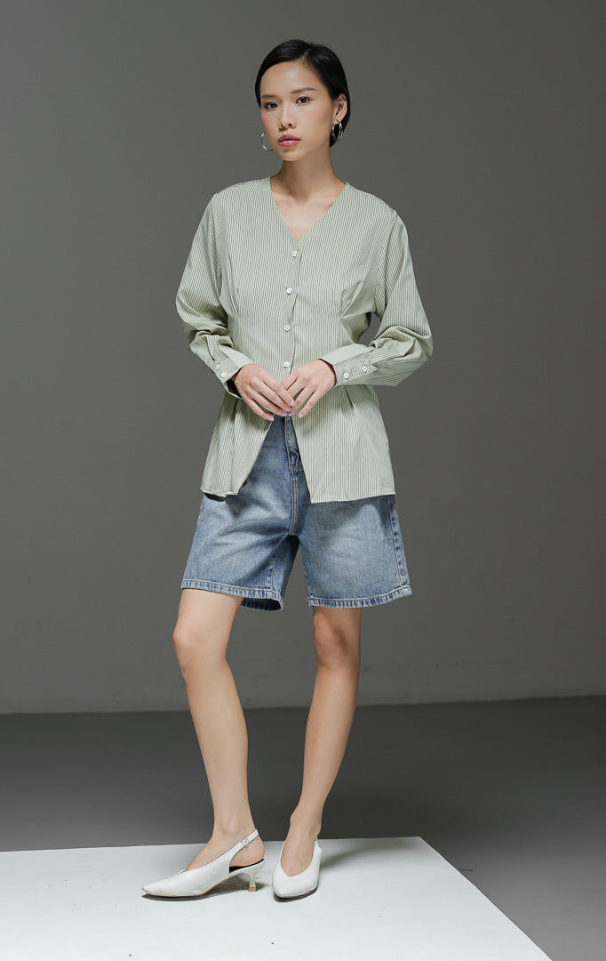 Atasan wanita Finnegan Top warna light green motif pinstripe salur halus dengan kerah V-neck, lengan panjang, dan kancing depan.