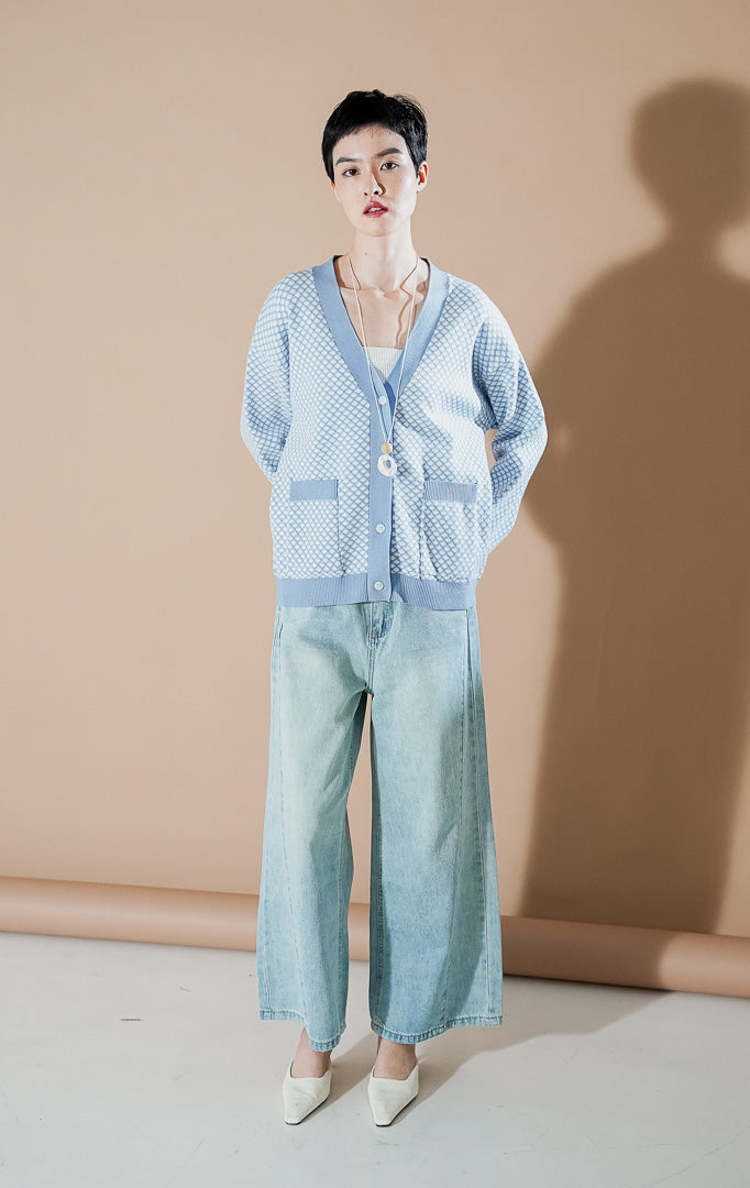 Model wanita mengenakan Gilda Patterned Knit Cardigan warna Blue, kardigan rajut v-neck dengan motif ketupat kecil (diamond pattern) dan saku depan dari This Is April.