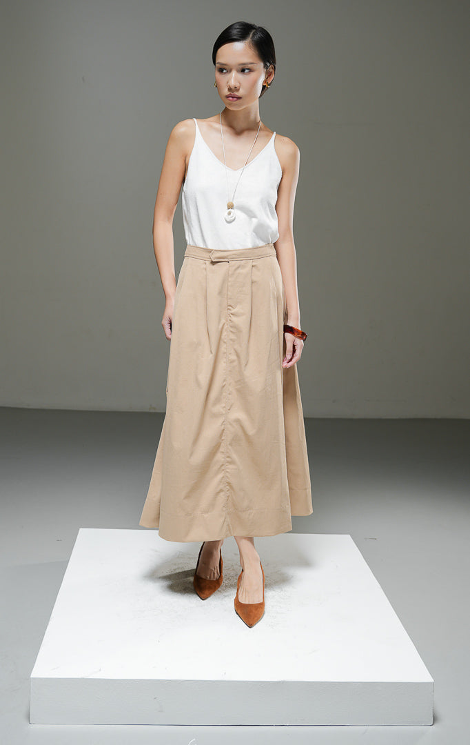 Rok midi wanita Gracelyn Skirt warna light brown cokelat muda model A-line high waist dengan detail lipat pleat di depan dan kantong samping.