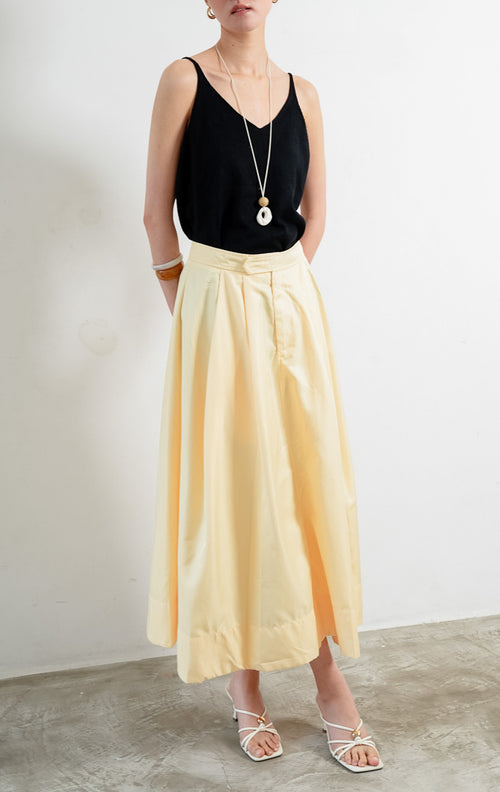 Rok panjang wanita model maxi warna kuning (yellow maxi skirt) Hadley Skirt bahan tenun ringan (lightweight woven fabric) dengan pinggang tinggi (high-rise waist), siluet A-line berpotongan melebar (A-line silhouette), serta detail kerut halus di bagian pinggang.