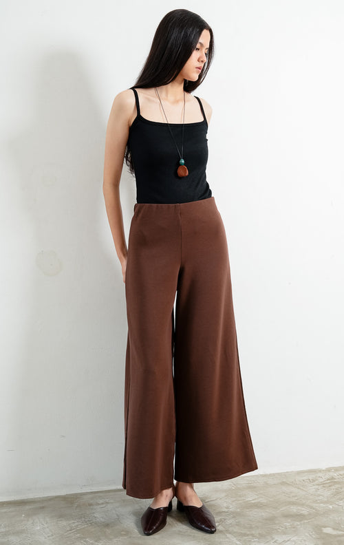 Celana panjang wanita warna cokelat tua (dark brown long pants) Hadrian Pants dengan siluet lurus (straight-leg silhouette), konstruksi bahan rajut rib bertekstur (textured rib knit construction), dan ban pinggang fleksibel (flexible waistband).
