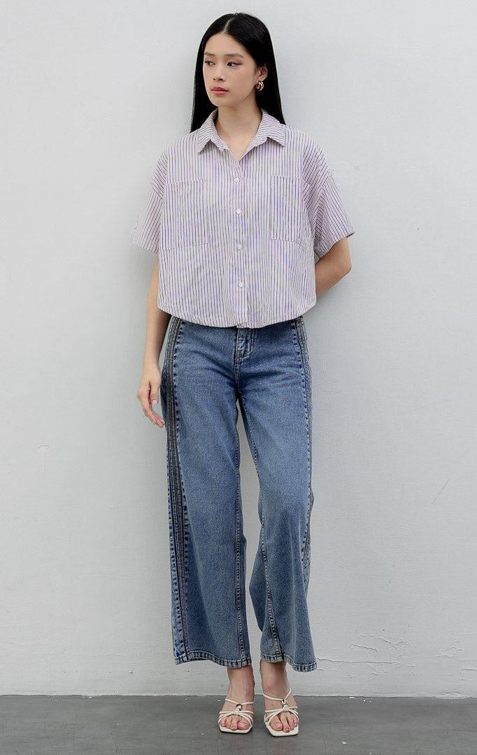 Kemeja katun wanita lengan pendek potongan boxy warna merah muda (pink) Hampton Top berkerah (spread collar) dengan motif garis vertikal (striped pattern), kancing depan, dan saku dada.