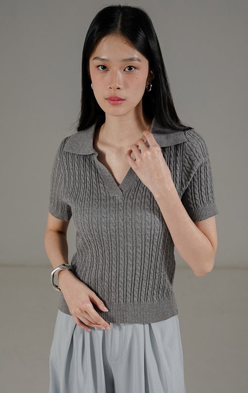 Eiden Top Dark Grey dari This Is April, atasan rajut lengan pendek warna abu-abu tua dengan motif cable knit dan potongan kerah V.