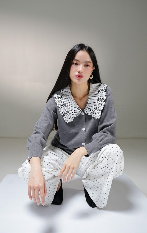 Kardigan rajut lengan panjang wanita This Is April Kaira Cardigan warna abu-abu tua (dark grey), dengan kancing depan putih dan detail kerah v-neck renda (lace) motif bunga warna putih.