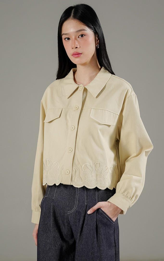 Kennedy Jacket Ivory dari This Is April, jaket lengan panjang warna putih tulang (ivory) dengan detail bordir eksklusif di bagian bawah dan saku depan.