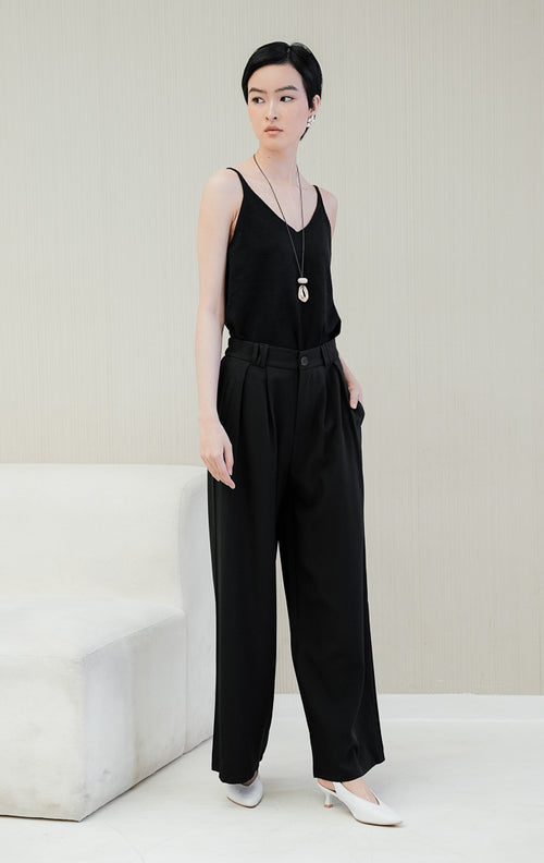 Celana panjang kulot wanita Kalia Pleats Wide Leg Pants warna black (hitam) berpotongan wide-leg dengan aksen lipit depan (pleats) dan saku samping untuk formal & casual look.
