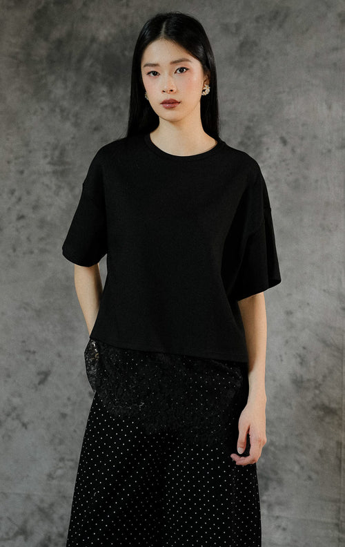 Kemeja oversized lengan panjang wanita Kaori warna hitam berbahan katun dengan detail aksen renda lace manis di sepanjang keliman hem bawah.