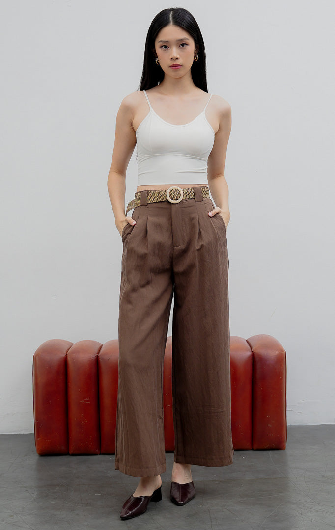 Celana kulot panjang wanita model longgar (wide-leg pants) warna cokelat (brown) Maeve Pants berbahan campuran katun-linen (cotton-linen blend) dengan aksen lipit depan (front pleats), kancing depan, dan saku samping.