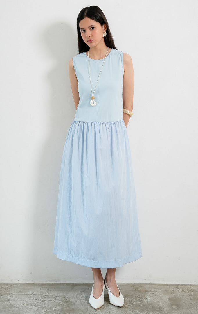 Dress wanita tanpa lengan warna biru (blue sleeveless dress) Maevera Dress dengan kombinasi atasan bahan stretch jersey dan rok kerut bahan crinkle ringan (lightweight crinkle fabric skirt), serta kerah bulat (round neckline).