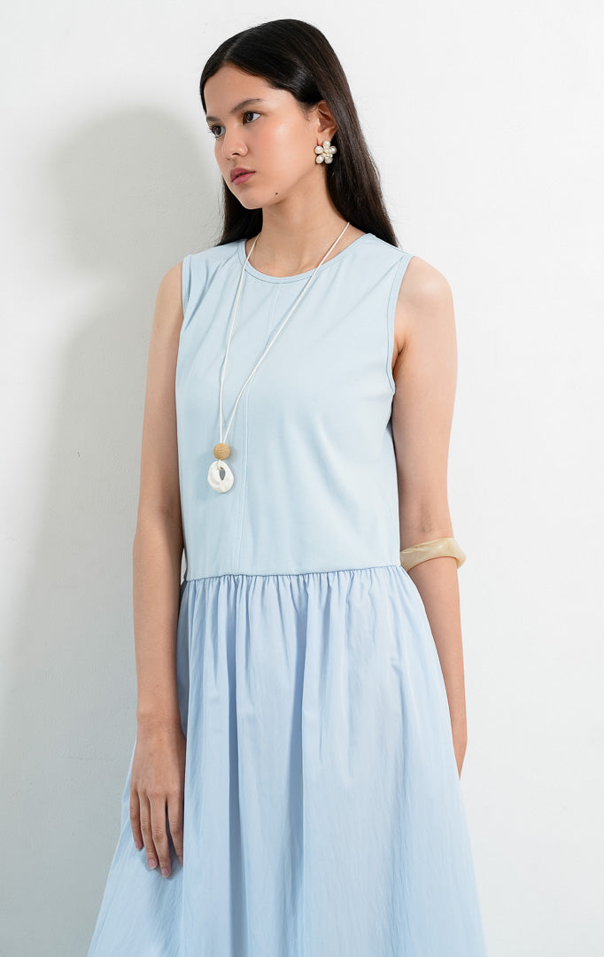 Dress wanita tanpa lengan warna biru (blue sleeveless dress) Maevera Dress dengan kombinasi atasan bahan stretch jersey dan rok kerut bahan crinkle ringan (lightweight crinkle fabric skirt), serta kerah bulat (round neckline).