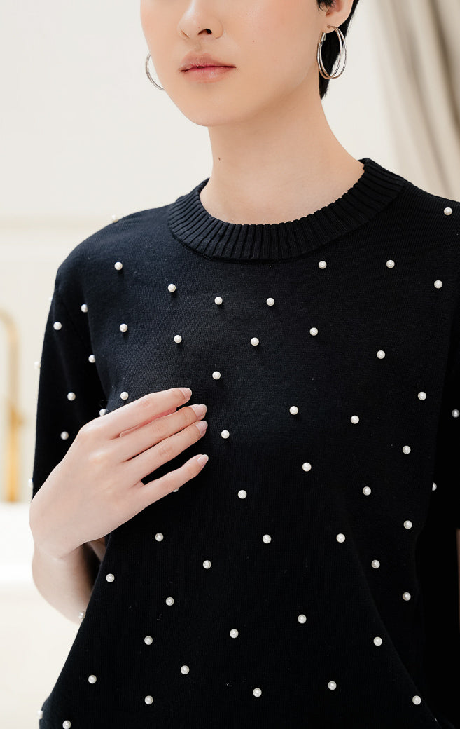 Atasan rajut wanita warna hitam Maple Top dengan aksen hiasan mutiara pearl studded, kerah bulat crew neck, dan lengan pendek yang elegan.