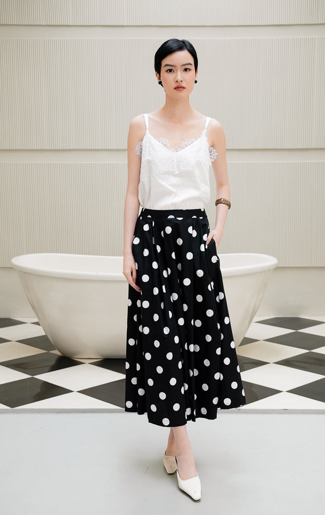 Rok panjang wanita Maroline Skirt warna black (hitam) motif polka dot putih model flare maxi berbahan cotton dengan pinggang karet dan saku fungsional.