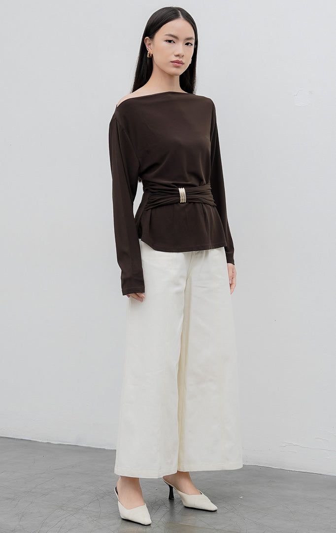 Atasan lengan panjang wanita warna cokelat tua (dark brown) Mezza Top berbahan jersey stretch dengan aksen draped, kerut pinggang (gathered waist), dan hiasan bros (brooch).