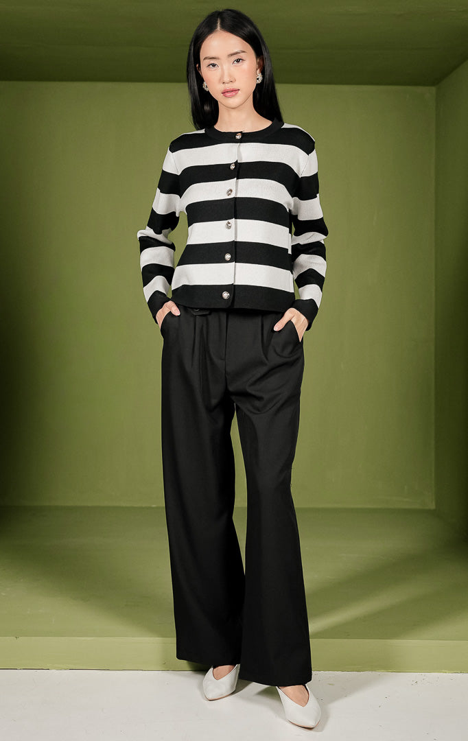 Atasan rajut wanita Mia Top lengan panjang dengan motif garis horizontal berwarna hitam dan putih, dilengkapi kerah bulat (crew neck) dan deretan kancing berwarna emas di bagian depan.