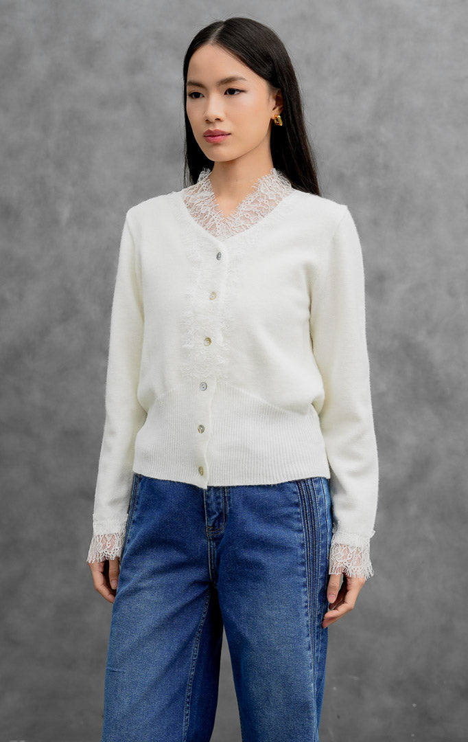 Sweter rajut wanita lengan panjang warna putih (white) Mirabel Sweater dengan kerah V (V-neck), aksen rendetan renda halus (lace trim), dan kancing depan.