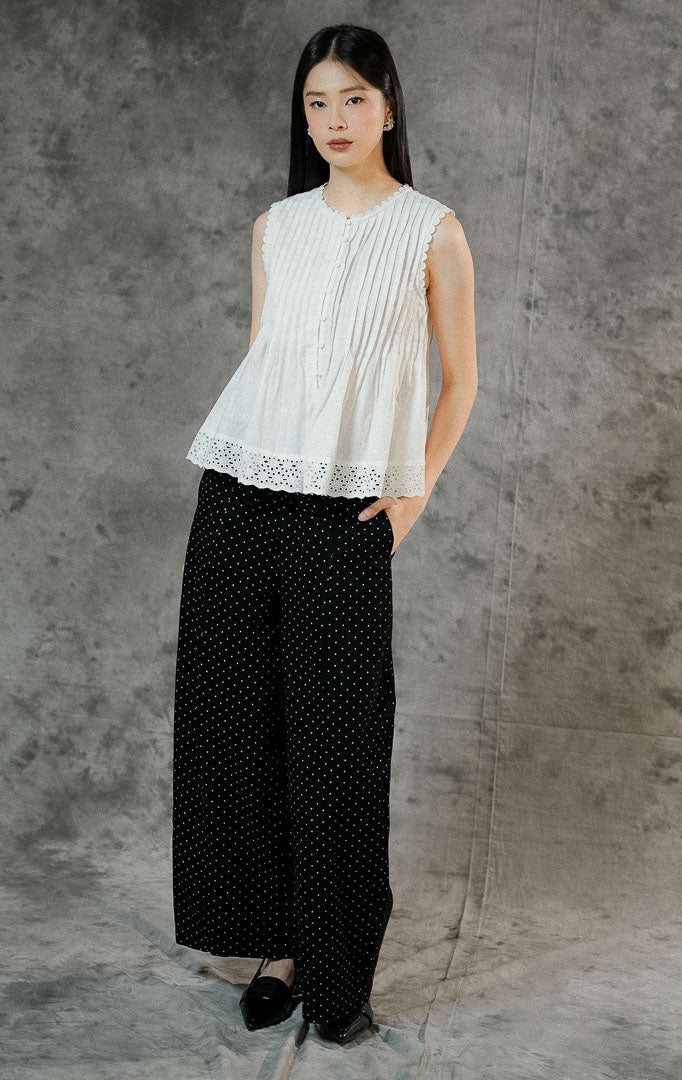 Blouse peplum tanpa lengan wanita Misty warna putih bersih berbahan katun dengan detail pintuck, kerah berhias lace bordir, dan keliman ruffle bawah.