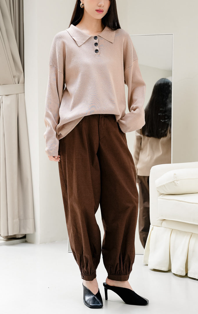 Sweater rajut wanita warna cokelat muda Neddra Sweater dengan tekstur fine-ribbed, detail kerah (collared neckline), lengan panjang, dan potongannya yang rapi.