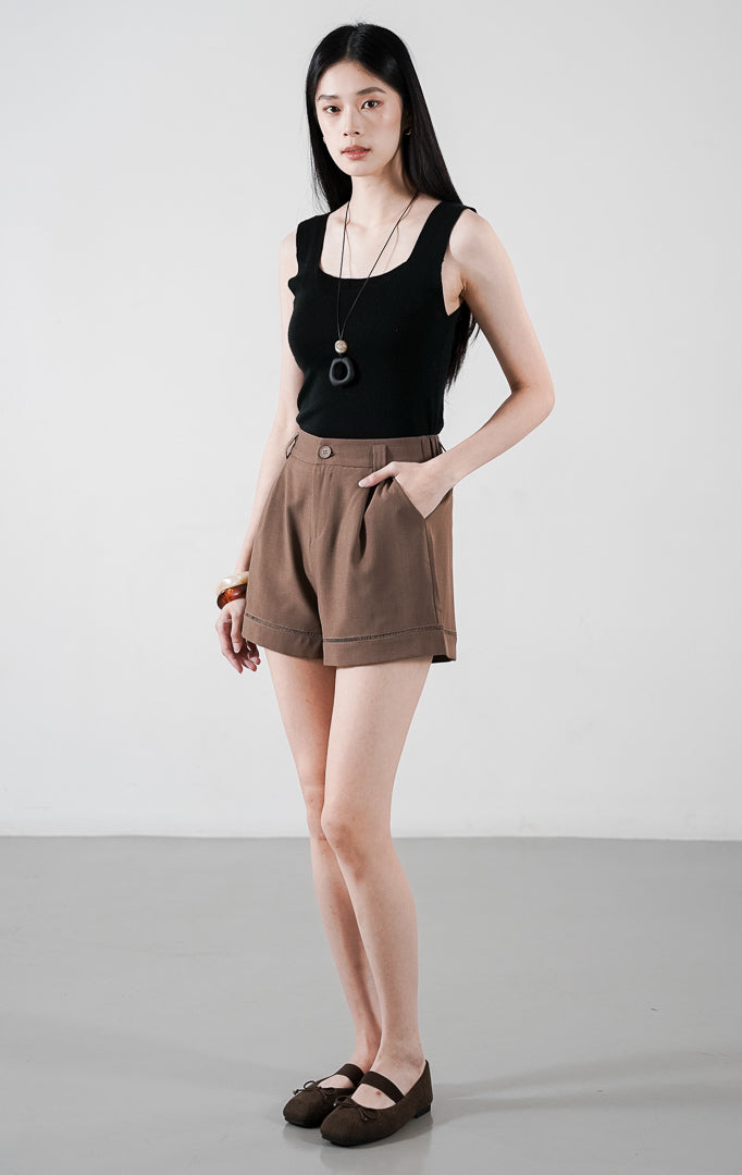 Nico Pants warna cokelat (brown), celana pendek wanita dengan detail kancing depan senada, saku samping, dan aksen jahitan rapi pada hem bawah.