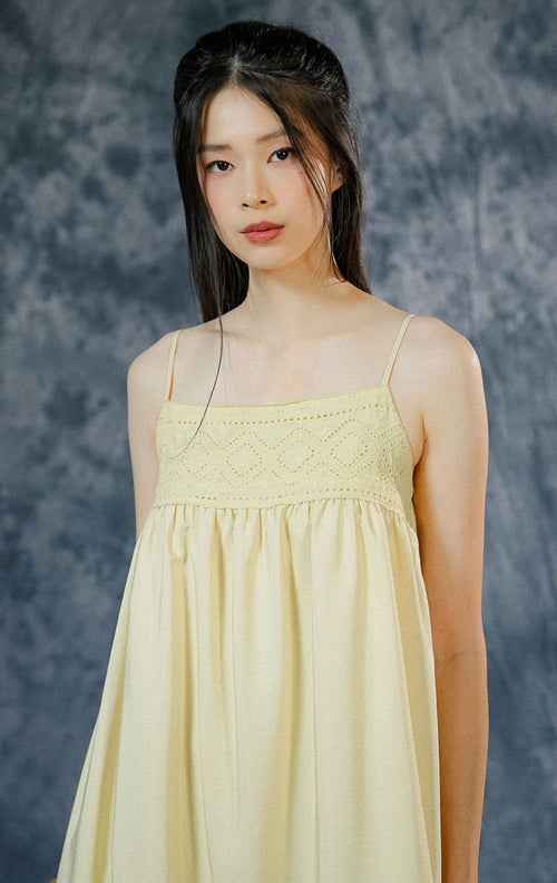 Dress panjang tanpa lengan (maxi dress) wanita Norah warna kuning mentega (butter yellow) dengan detail aksen crochet, hem ruffle bawah, dan tali pundak adjustable.