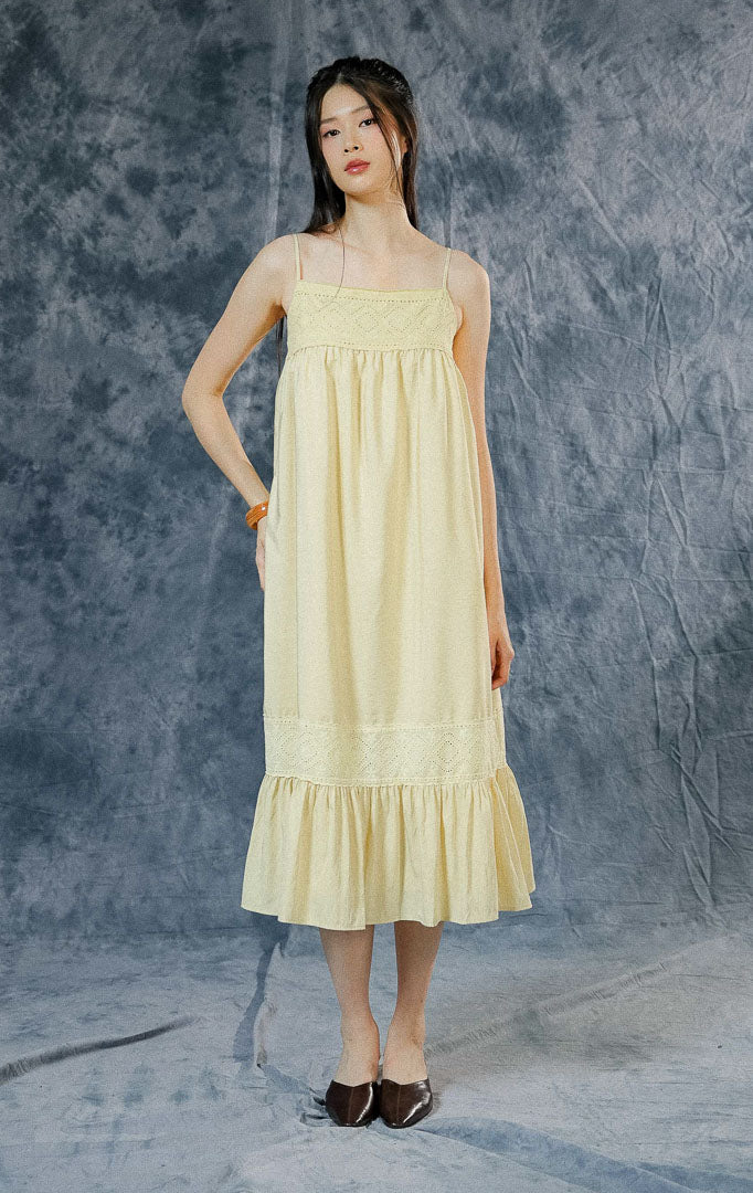 Dress panjang tanpa lengan (maxi dress) wanita Norah warna kuning mentega (butter yellow) dengan detail aksen crochet, hem ruffle bawah, dan tali pundak adjustable.