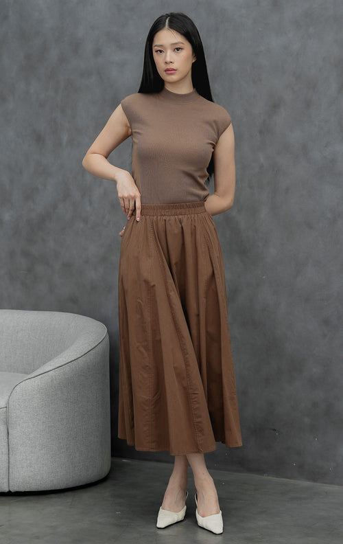Rok maxi wanita model mekar (flared) warna cokelat tua (dark brown) Ophelia Skirt dengan detail jahitan panel, saku samping, dan pinggang full karet.