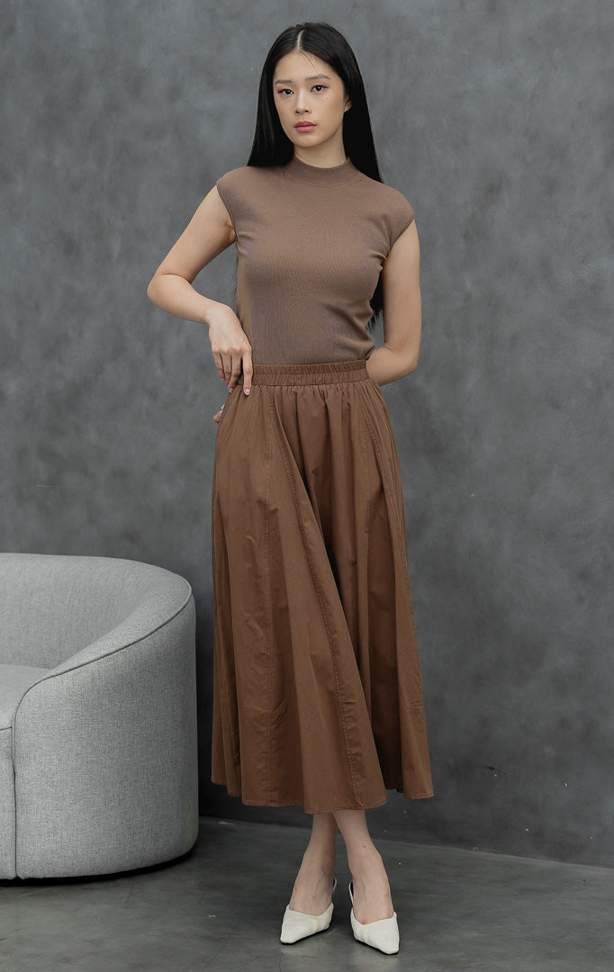 Rok maxi wanita model mekar (flared) warna cokelat tua (dark brown) Ophelia Skirt dengan detail jahitan panel, saku samping, dan pinggang full karet.
