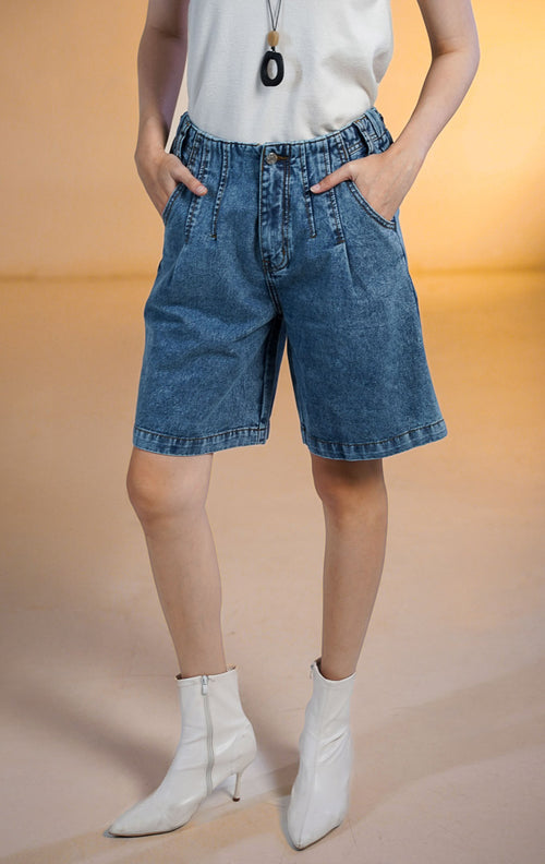 Model wanita mengenakan SH Ophira Short Denim Pants celana pendek denim selutut (Bermuda) dengan pinggang karet dan saku samping, dan dipadukan dengan tank top hitam