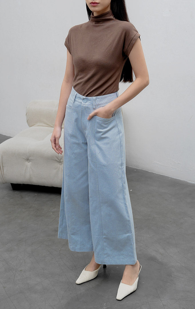 Celana panjang wanita model lebar (wide-leg pants) warna biru muda (light blue) Orian Pants berbahan cotton twill dengan jahitan panel melengkung (curved panel lines), saku utility depan, dan kancing resleting.