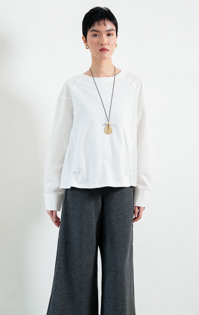Sweater wanita lengan panjang warna putih (white long sleeve sweater) Orivelle Sweater dengan kombinasi bahan jersey lembut dan kain katun ringan (lightweight cotton fabric), kerah bulat (rounded neckline), serta potongan lengan raglan (raglan-style sleeves).