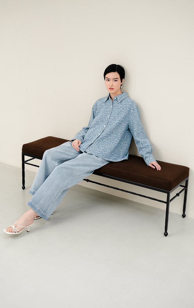 Kemeja jeans wanita Panthera Top warna light denim biru muda dengan tekstur motif leopard jacquard, lengan panjang, dan kancing depan.