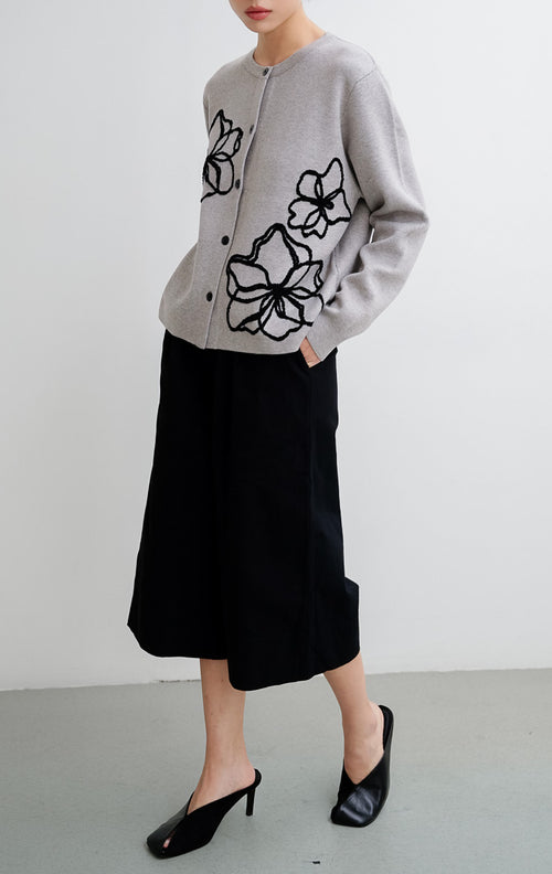 Cardigan rajut wanita warna abu-abu (grey) Peppie Cardigan berbahan soft stretch dengan detail bordir bunga (flower embroidery) dan kancing depan (button-up).