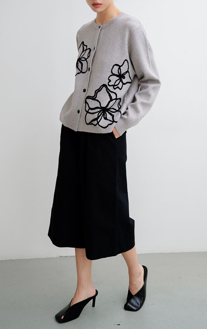 Cardigan rajut wanita warna abu-abu (grey) Peppie Cardigan berbahan soft stretch dengan detail bordir bunga (flower embroidery) dan kancing depan (button-up).