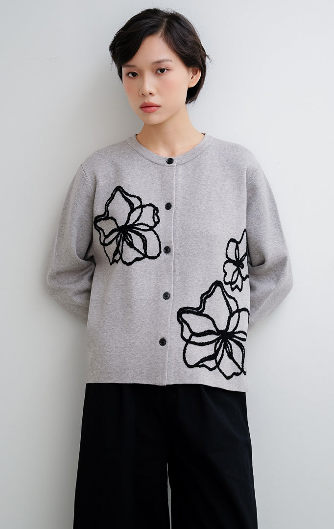 Cardigan rajut wanita warna abu-abu (grey) Peppie Cardigan berbahan soft stretch dengan detail bordir bunga (flower embroidery) dan kancing depan (button-up).