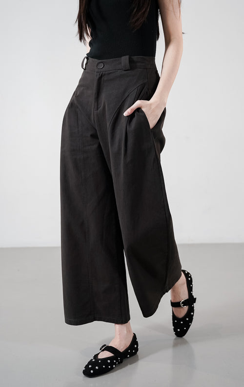 Detail depan Regina Pants warna dark grey, celana panjang dengan detail jahitan panel melengkung yang unik, saku samping, dan potongan lebar.