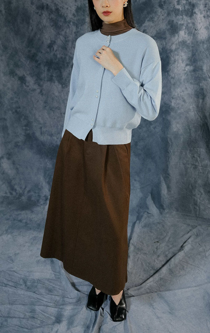 Cardigan lengan panjang wanita Rivere warna biru muda (light blue) berbahan rajut premium dengan detail dua kancing depan bergaya mutiara.