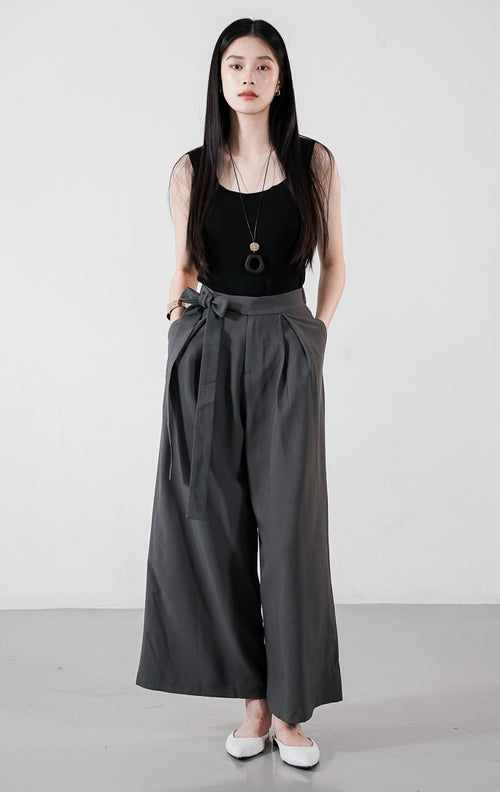 Rovero Pants warna abu-abu (grey), celana panjang wanita wide-leg dengan detail tali pinggang yang diikat simpul dan aksen lipatan plisket halus.