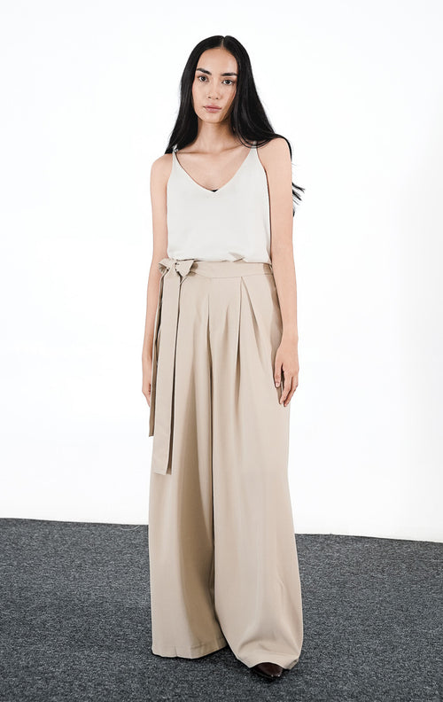 Rovero Pants warna khaki, celana panjang wanita wide-leg dengan detail tali pinggang yang diikat simpul dan aksen lipatan plisket halus.