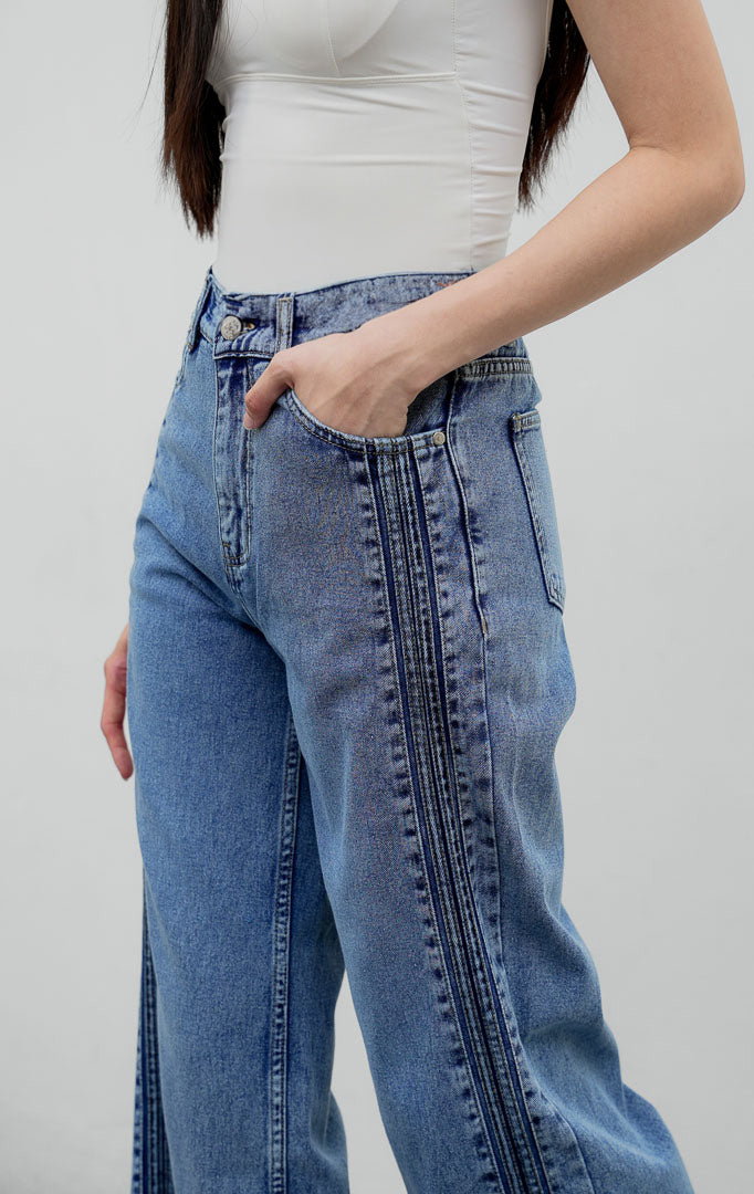 Celana jeans wanita model lurus (straight leg) warna biru muda (light denim) Rovex Pants dengan aksen jahitan lipit samping (pintuck detailing), saku fungsional, dan pinggang karet belakang.