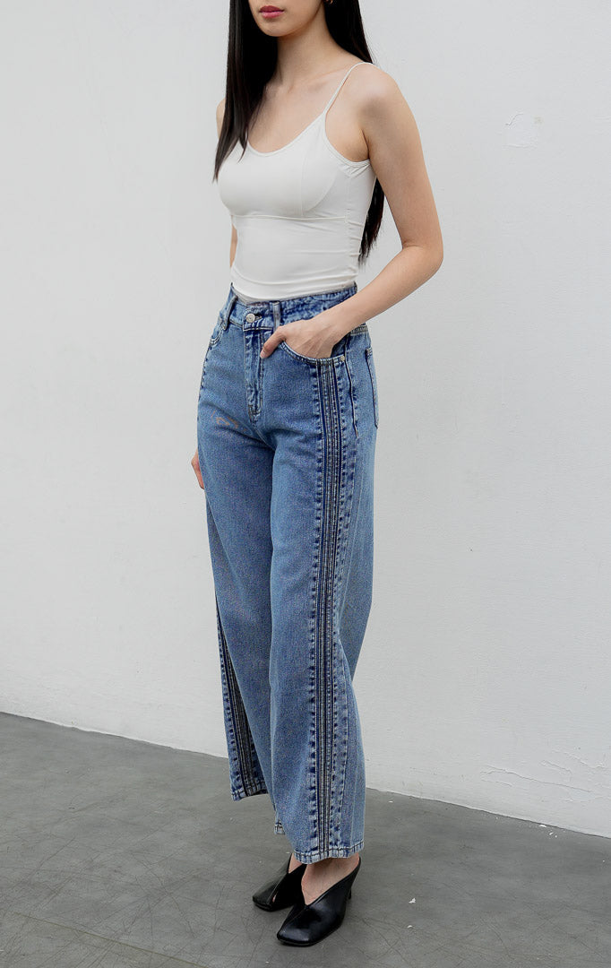 Celana jeans wanita model lurus (straight leg) warna biru muda (light denim) Rovex Pants dengan aksen jahitan lipit samping (pintuck detailing), saku fungsional, dan pinggang karet belakang.