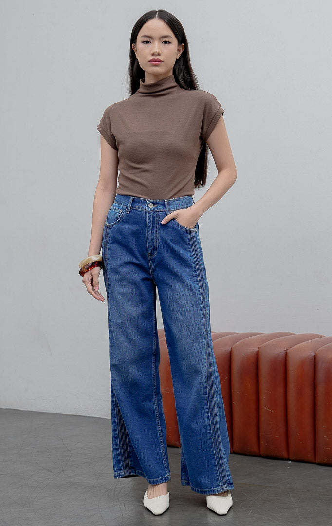 Celana jeans wanita model lurus (straight leg) warna biru medium (denim) Rovex Pants dengan aksen jahitan lipit samping (pintuck detailing), saku fungsional, dan pinggang karet belakang.