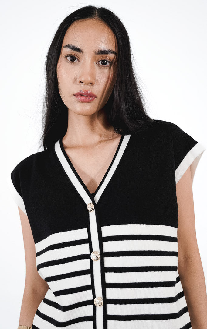 Rucci Set warna hitam, setelan rajut yang terdiri dari rompi v-neck motif garis putih dengan kancing emas dan celana panjang hitam.