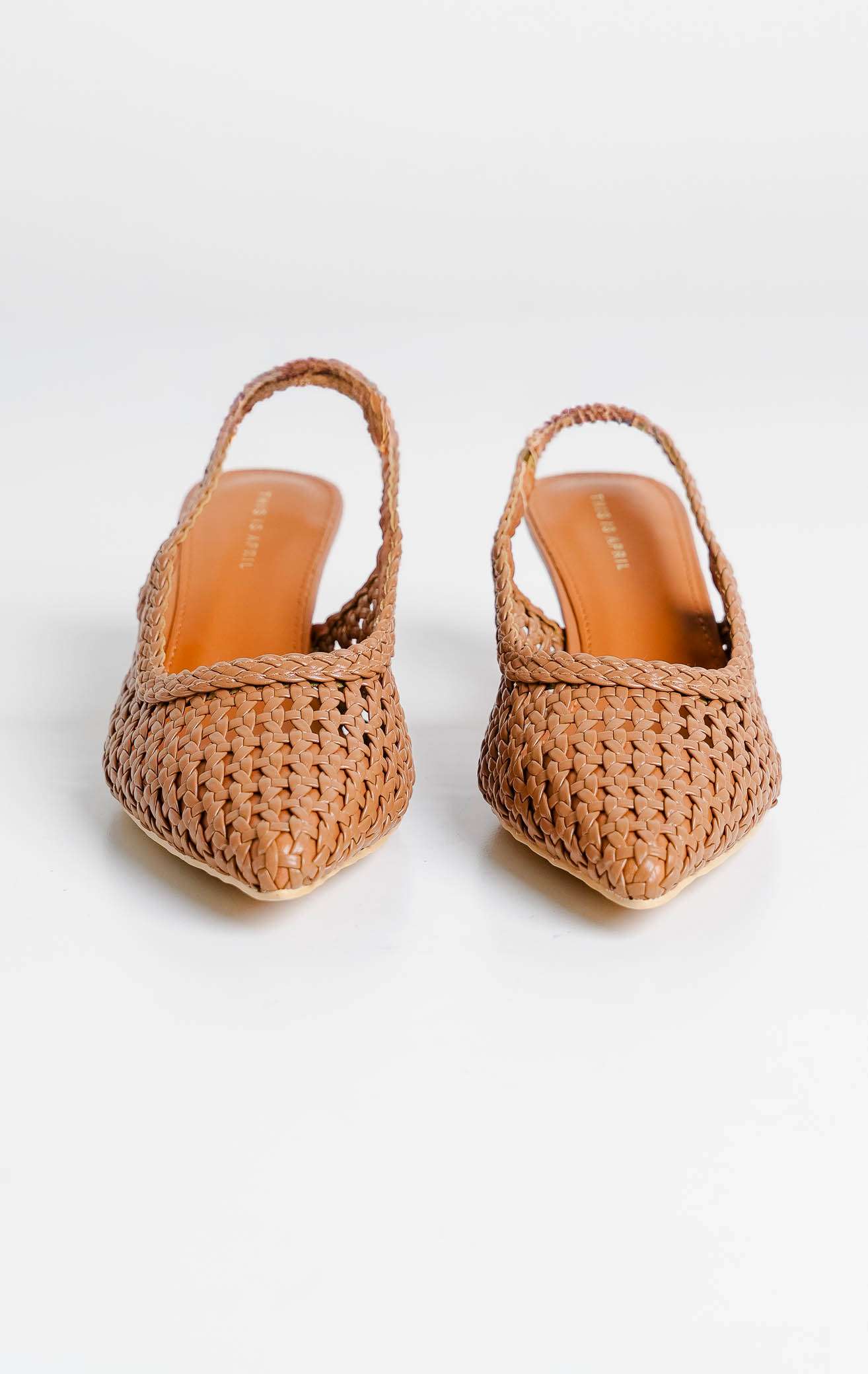 Tampilan flat lay sepasang Avaia Heels warna camel, sepatu hak rendah wanita model slingback heels ujung runcing pointed toe bahan kulit anyaman warna cokelat tan dari This Is April.