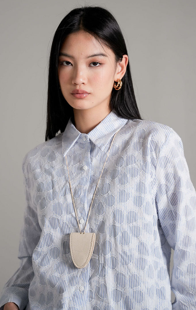 Serena Top Blue, kemeja katun lengan panjang dengan motif garis-garis biru putih dan aksen pola bunga, dipadukan dengan rok mini jeans denim