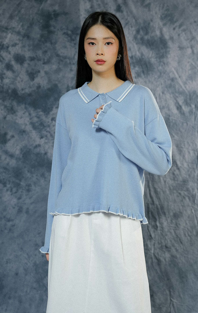 Atasan baju rajut wanita Sinclair warna biru muda (light blue) lengan panjang berkerah polo dengan paduan list garis putih dan keliman ruffle yang manis.