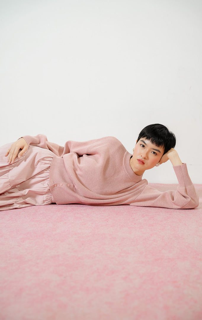 Detail dekat Cerise Button Hem Knit Sweater warna dusty pink, atasan sweater rajut wanita lengan panjang dengan karet pinggang rib lebar berdetail kancing.