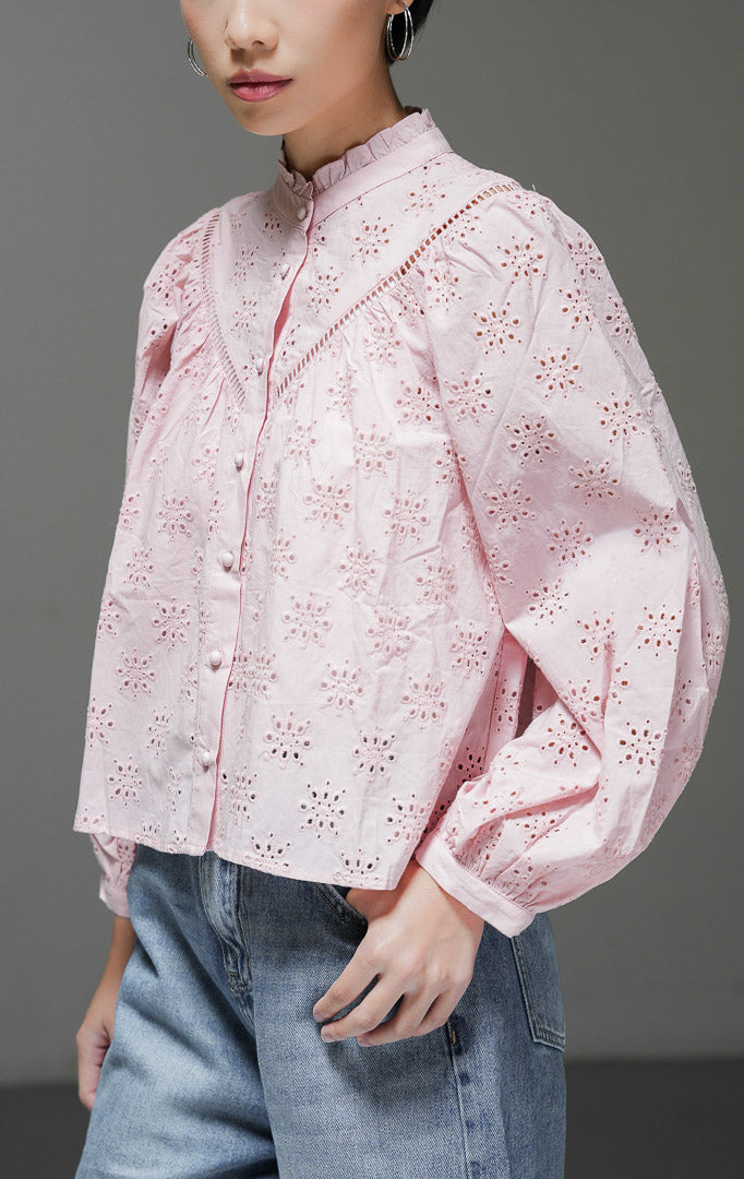 Atasan blouse wanita Sylvia Top warna pink bahan eyelet bordir dengan detail kerah frill rumbai dan kancing depan bungkus yang manis.