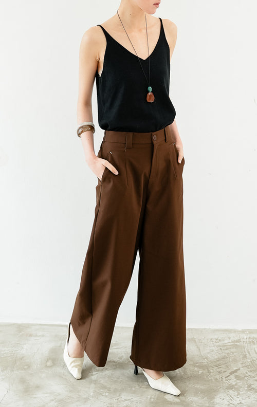 Celana panjang wanita siluet lurus (straight-leg trousers) warna cokelat tua (dark brown) Sylvie Pants dengan ban pinggang terstruktur berloop ikat pinggang (belt loops), kancing depan, saku miring, dan karet elastis di bagian belakang pinggang (elasticated back waistband).