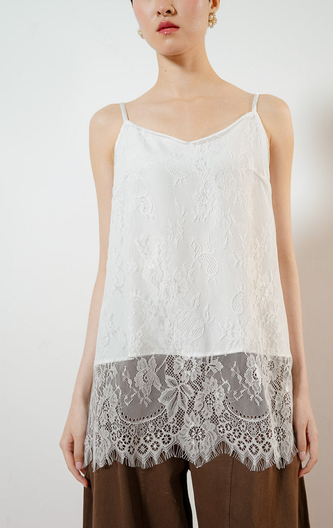 Model wanita mengenakan Juliet Lace Tank Top warna white, atasan camisole tank top satin wanita berwarna putih dengan detail kelim renda brokat bunga transparan yang anggun.