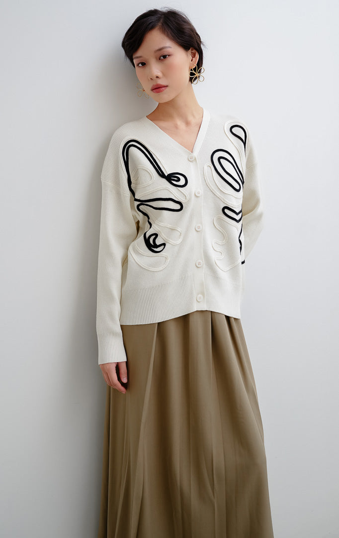 Cardigan rajut wanita warna ivory (putih tulang) Thea Cardigan berbahan stretchy bertekstur motif unik dengan penutup kancing depan (button closure)